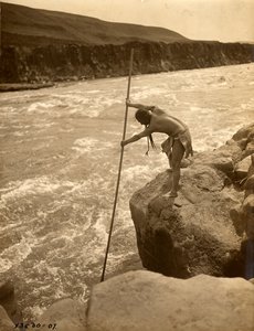 Tlakluit-Indianer, stehend auf Felsen, fischend mit Dip-Netz, ca. 1910 (s/w Foto) von Edward Sheriff Curtis