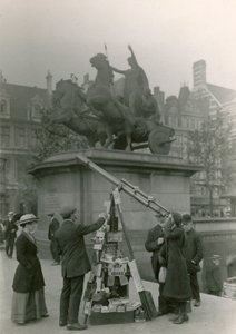 Ein Mann verkauft Ansichten durch ein Teleskop von English Photographer