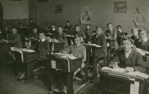 Männliche Schüler sitzen während einer Unterrichtsstunde an ihren Schreibtischen