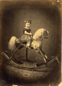 Junges Mädchen auf einem gesprenkelten Schaukelpferd von English Photographer