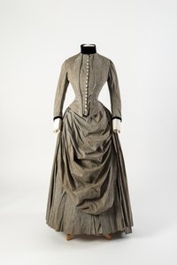 Graues Baumwollkleid mit drapiertem Schürzenfront und schwarzem Samtbesatz am Kragen und an den Manschetten, späte 1880er Jahre von English School