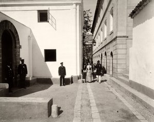 Männer in Uniform begleiten eine elegant gekleidete Frau zur Kirche des Bauernhofs Lo Zucco, Sizilien, 1900 von Eugenio Interguglielmi