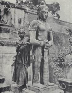 Junger buddhistischer Novizenmönch neben einer Buddha-Statue, Französisch-Indochina (s/w Foto)