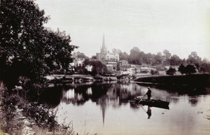 Die Stadt Ross-On-Wye, vom Ufer des Flusses aus gesehen. Im Vordergrund steht ein Mann auf einem Ruderboot