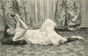 Mädchen, das auf dem Boden liegt und einen Ball über dem Kopf hält von French Photographer