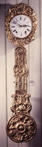 Comptoise-Uhr mit gepresstem Messingrahmen um das Zifferblatt und Detail des Pendels