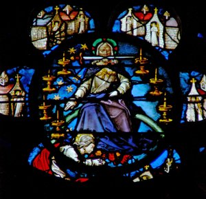 Das Westrosenfenster zeigt eine Szene aus dem Buch der Offenbarung: Christus auf einem Regenbogen thronend, umgeben von sieben goldenen Leuchtern und den sieben Kirchen Asiens. In seinem Mund ist das scharfe zweischneidige Schwert. von French School