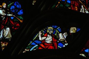 Das westliche Rosenfenster zeigt eine Szene aus dem Buch der Offenbarung: ein Engel (auf einem Regenbogen) gibt Johannes ein offenes Buch (10:1,8).
