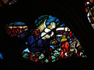 Das westliche Rosenfenster zeigt eine Szene aus dem Buch der Offenbarung: ein Engel, der das Altarfeuer nimmt und es auf die Erde wirft (8:5).