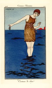 Frau im Badeanzug bis zu den Knöcheln im Meer am Strand, die eine Krabbe hält