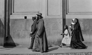 Russisch-orthodoxer Priester spaziert auf dem Bürgersteig, gefolgt von seiner Frau und zwei Kindern in Moskau von Gilbert H. Grosvenor