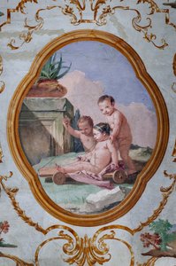 Gästeunterkünfte, der Raum der Putti, Medaillon mit Putti: "Drei Putti und ein Wagen"