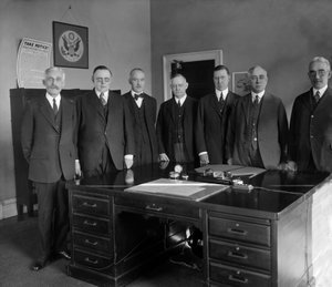Federal Reserve Board, von links nach rechts: Sekretär Mellon; W.P.G. Harding; Vizegouverneur Edmund Platt; Charles S. Hamlin; Adolph Miller; Rechnungsprüfer D.R. Crissinger und J.R. Mitchell. Fotografie von Harris & Ewing, um 1905 / 1945. von Harris & Ewing