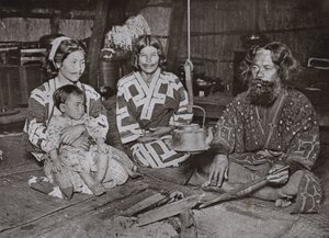 Ainu-Mann und Frauen zu Hause
