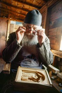 Ein Meisterschnitzer und orthodoxer Priester posiert mit seiner Arbeit. Berg Athos, Griechenland.