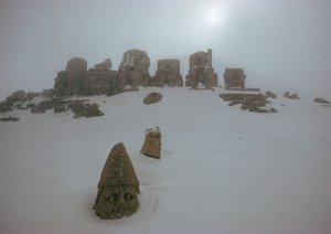 Statue eines Gottes ragt über eine Schneedecke am Nemrud Dagh. Nemrud Dagh, Türkei. von James L Stanfield