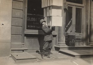 Wagenjunge oder Schwanzjunge hilft beim Beladen des Wagens, ca. 1914