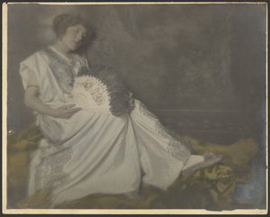 Florence sitzt mit großem Fächer