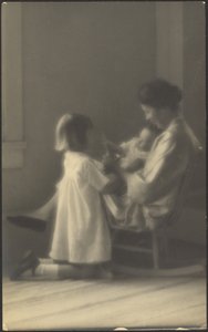 [Mutter im Schaukelstuhl mit Kindern]