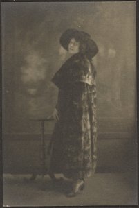[Porträt einer Frau im langen Mantel vor Wandteppich] von Louis Fleckenstein