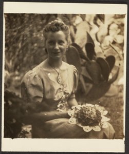 [Frau mit Blumenstrauß vor Kaktus sitzend] von Louis Fleckenstein