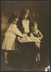 Frau und Kinder mit Bilderbuch von Louis Fleckenstein