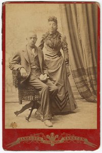 Fotografie eines afroamerikanischen Mannes und einer Frau in formeller Kleidung