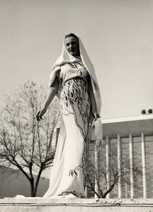 Modell in einem Abendkleid aus Blumenstoff, kreiert vom Modehaus "Lamma". Das Kleid wird mit einem langen Schleier ergänzt. von Luis Bogino