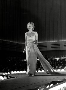 Modell auf dem Laufsteg in einem Abendkleid mit Strass-Trägern; kreiert vom Modehaus "Fumach".