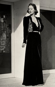Modell trägt ein langes Abendkleid aus dunklem Samt mit Stickereien, kreiert vom italienischen Modehaus "Fercioni".