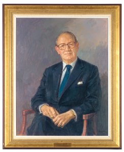 Porträt von Lord Aldington, sitzend im dunklen Anzug von Michael Noakes