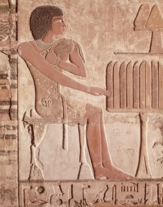 Relief, das den Verstorbenen zeigt, wie er vor einem Opfertisch mit Brot sitzt von Old Kingdom Egyptian
