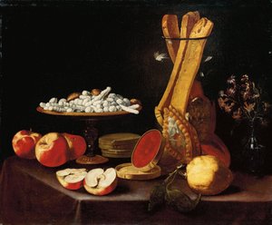 Süßigkeiten auf einer Tazza, Narzissen in einer Glasvase, Brotstangen in einem Glas und Äpfel, Gelee und eine Zitrone auf einem drapierten Tisch