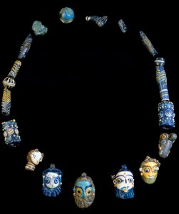 Halskette aus Glas mit Anhängern, die bärtige Köpfe darstellen, ursprünglich aus Olbia, jetzt im Nationalen Archäologischen Museum von Cagliari aufbewahrt