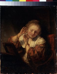 Junge Frau probiert Ohrringe an von Rembrandt Harmensz. van Rijn
