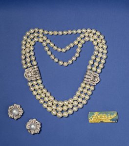 Auswahl an Perlenschmuck: dreireihige Perlenkette mit Diamantclips; boutonförmige Südsee-Kulturperlenohrringe; Gold- und Emaille-Brosche von Lalique, ca. 1900