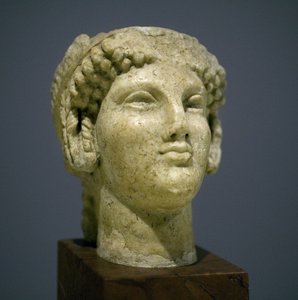 Mädchenkopf (Kore), Skulptur der römisch-hellenistischen Periode (3. 2. Jahrhundert nach unserer Zeitrechnung), sehr ausdrucksstarkes Gesicht, hervorstehende Wangenknochen nach Osten, Lächeln, lockiges Haar, archaischer Stil von Ionien im 6. Jahrhundert vo von Roman