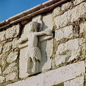 Christus am Kreuz Steinskulptur aus dem 13. Jahrhundert. Portal der romanischen Kirche San Bartolomeo, Campobasso Italien von Romanesque