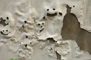 Italien, Toskana, Florenz, lächelnde Geistergesichter auf verwitterter bemalter Wand, 2022 (Foto) von Sisse Brimberg