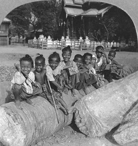 Burmesische Kinder sitzen auf einem Palmenstamm, Burma, 1908