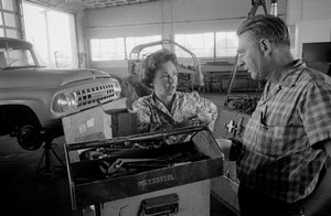 LKW-Fahrerin Mildred Cooper unterhält sich mit einem Mechaniker in einer Werkstatt