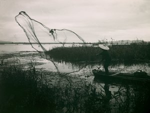 Japanischer Fischer wirft seine Netze auf einem See aus, um 1900 - 1915 von Teijiro Takagi
