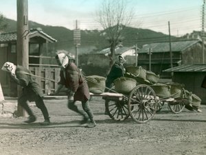Japanische Bauern ziehen Reissäcke auf einem Karren, um 1900 - 1915