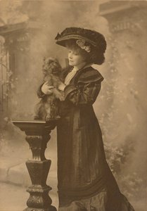 [Sarah Bernhardt in einem Studio, hält einen kleinen schwarzen Hund auf einem kunstvoll geschnitzten Holzsockel] von Theodore C. Marceau
