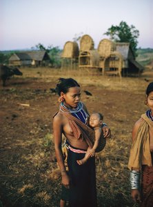 Khmer Loeu Mutter und ihr Kind in einer Schlinge und traditionellem Hügelstamm-Sarong in Phum
