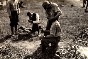 Österreichische Gefangene während des Ersten Weltkriegs in Bagnaria Arsa, Udine, Italien; im Vordergrund rasiert ein Soldat einen anderen Soldaten, 02.04.1916 von Ugo Ojetti