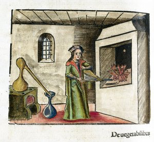 Alchemie 16. Jahrhundert: ein Alchemist bei der Arbeit, der einen Blasebalg vor dem Kamin seines Ateliers betätigt, hinter ihm ein Ofen und ein Destillierkolben