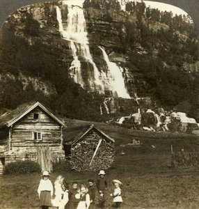 Kinder spielen auf einem Bauernfeld mit terrassiertem Tvinde-Wasserfall, Vossevangen, Norwegen von Unbekannt