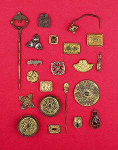 Sammlung von angelsächsischem und keltischem Schmuck, darunter vergoldete Bronzebeschläge, Untertassen- und Kreuzfibeln und ein merowingisches Anhänger, aus dem 1. bis 7. Jahrhundert n. Chr.