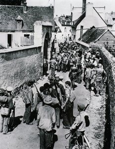 Gruppen französischer Widerstandskämpfer warten auf die Verteilung von Waffen in einem Haus, Juli 1944